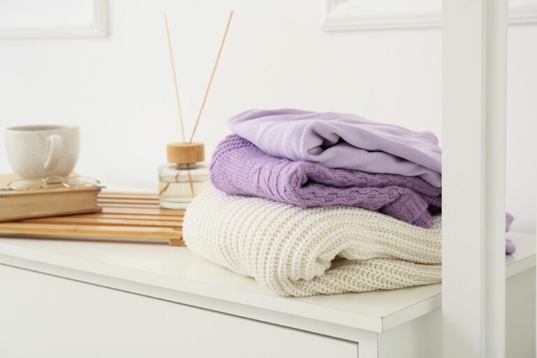 Knitted,Sweaters,On,Shelf,Near,Light,Wall