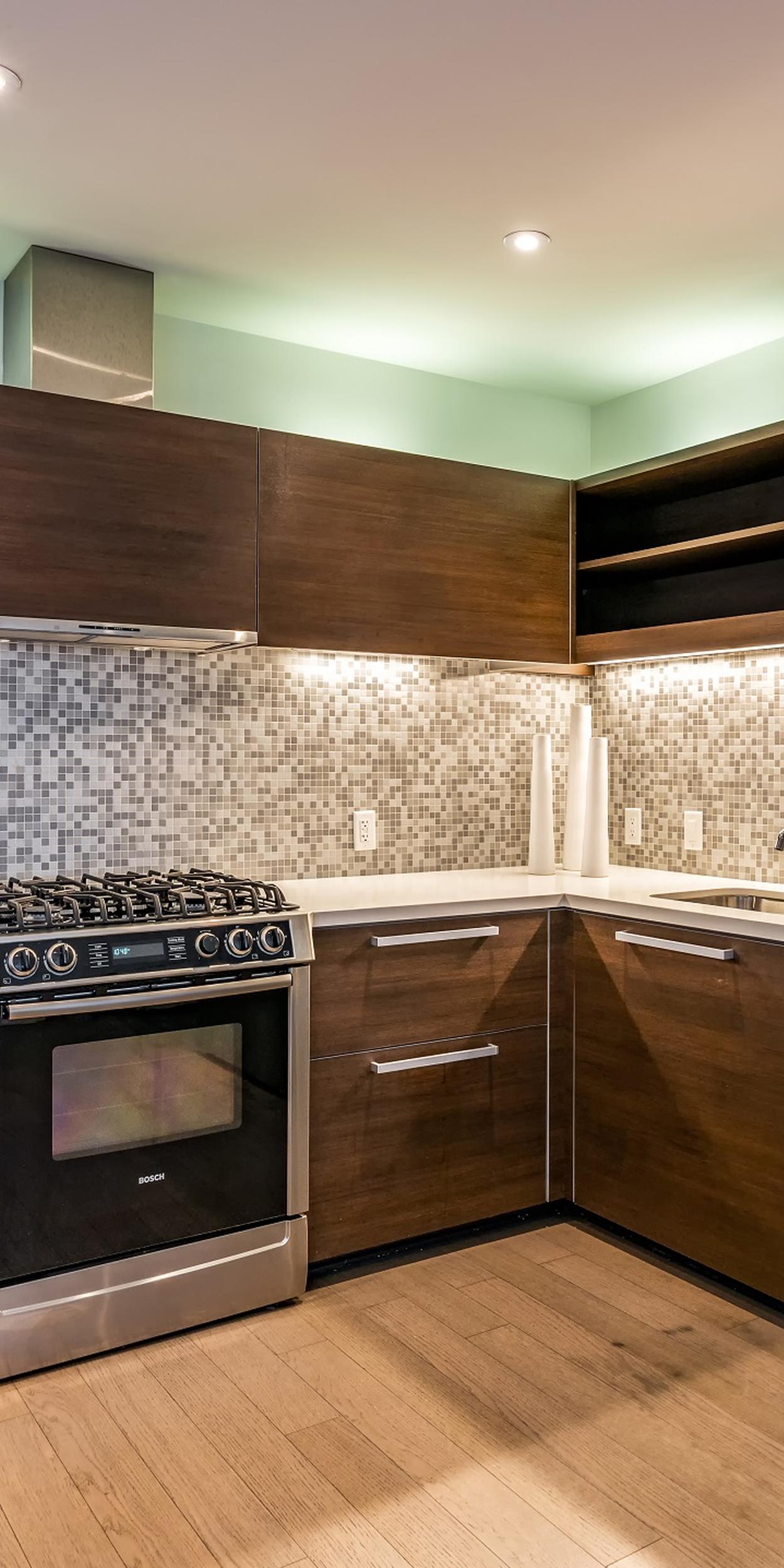 Berkeley, CA Apartments for Rent - Kitchen with Mosaic Tile Backsplash, Stainless Steel Appliances and Wood Flooring.